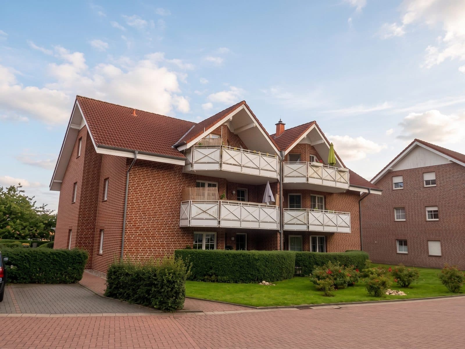 Wohnhaus in Borgholzhausen mit rotem Klinker, hellen Balkonbrüstungen und geneigtem Dach